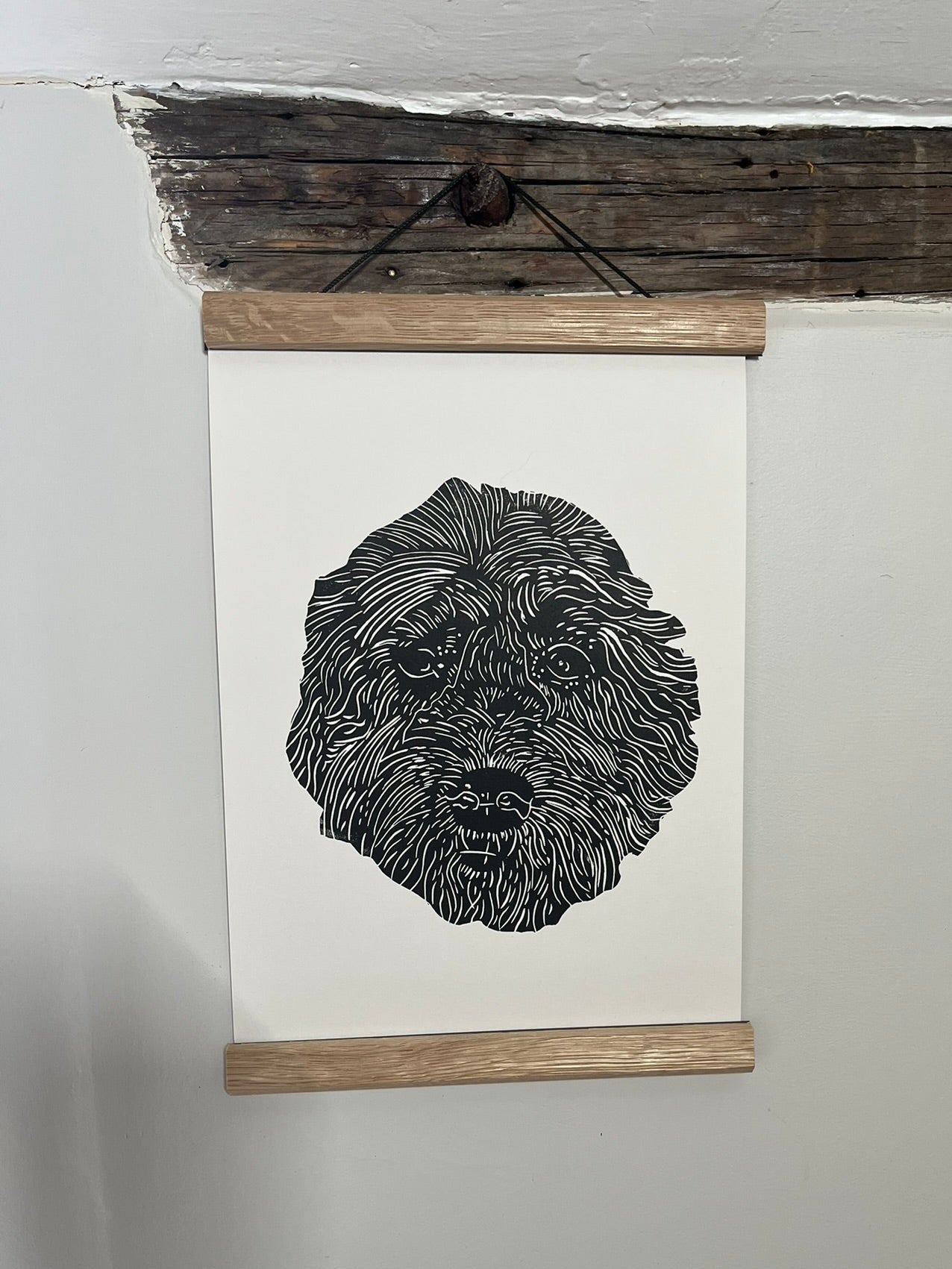 Black and white dog illustration on a white background with wooden frame hanging on a wall.